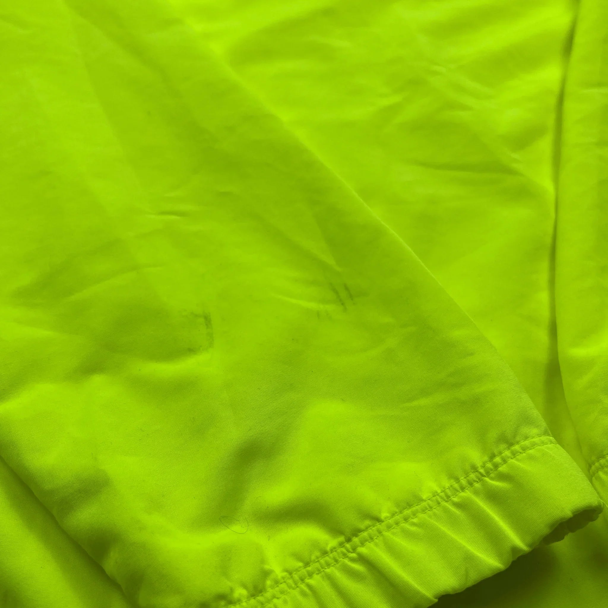 Nahaufnahme von leuchtend gelbem Stoff mit Bündchen der Nike Barcelona Trainingsjacke vintage