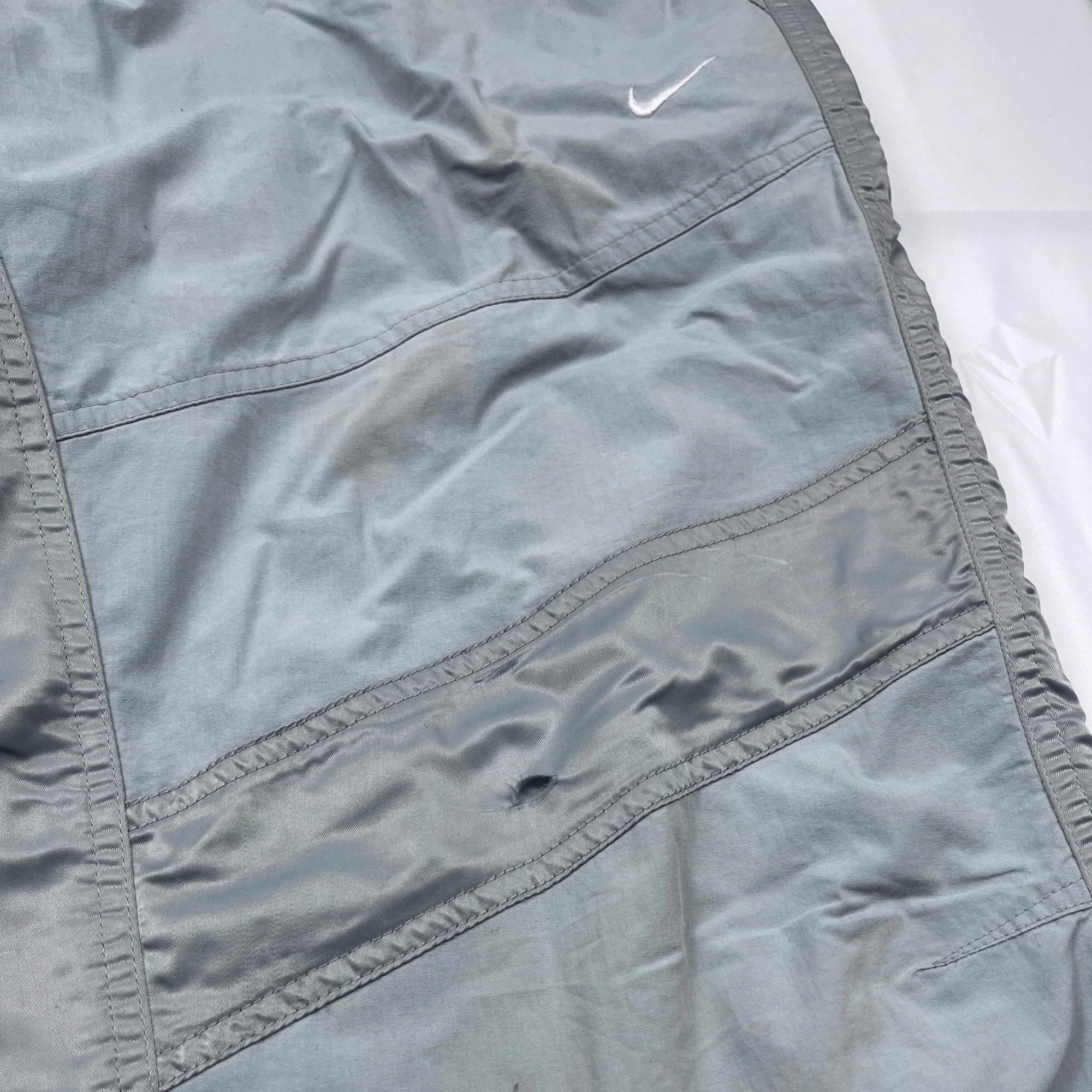 Nike Trackpants Vintage Firtst edition von Kickvault in grauer Farbe mit weißem Nike-Logo und elastischem Bund