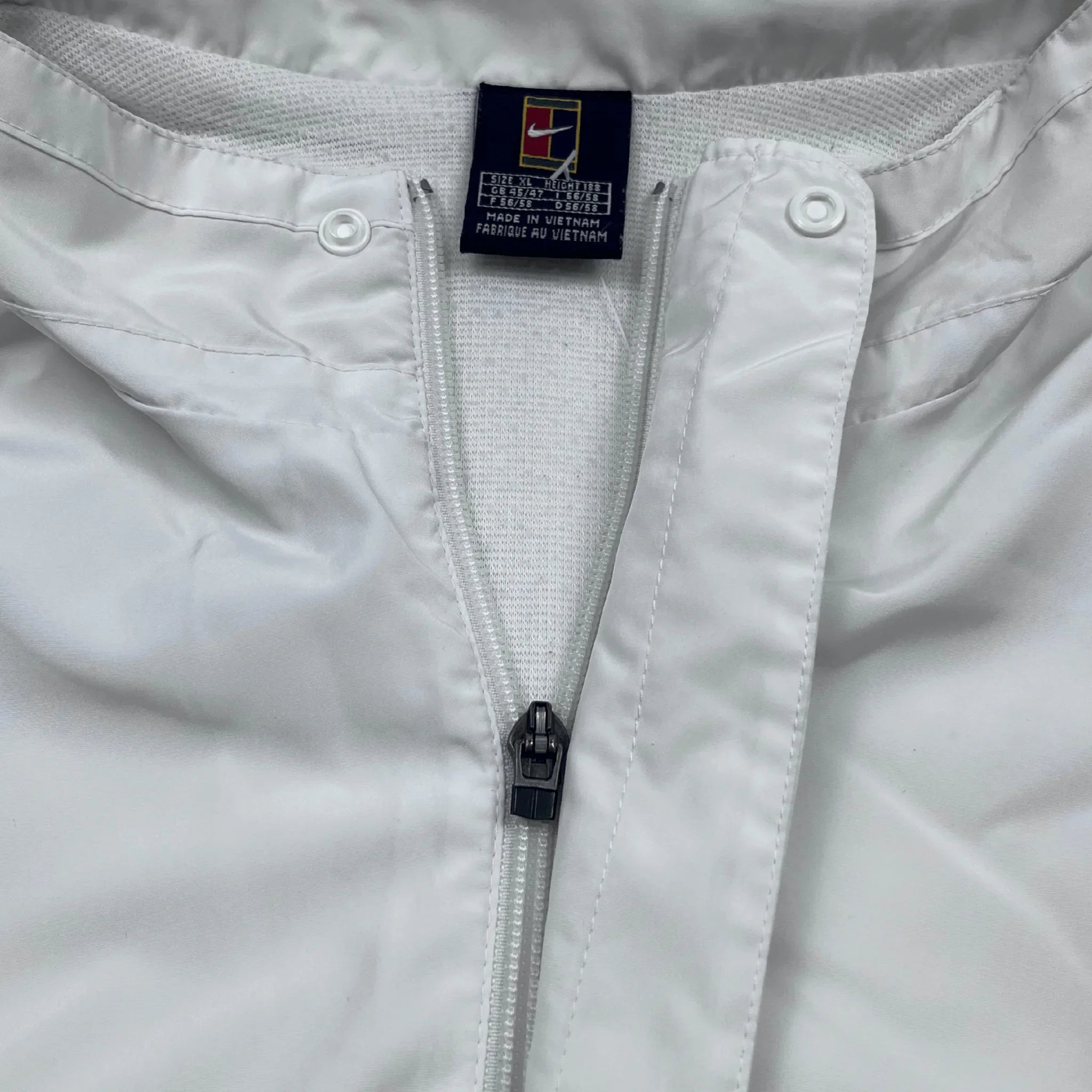 Weiße Nike Trainingsjacke Vintage mit Reißverschluss und Knöpfen von Kickvault Nahaufnahme