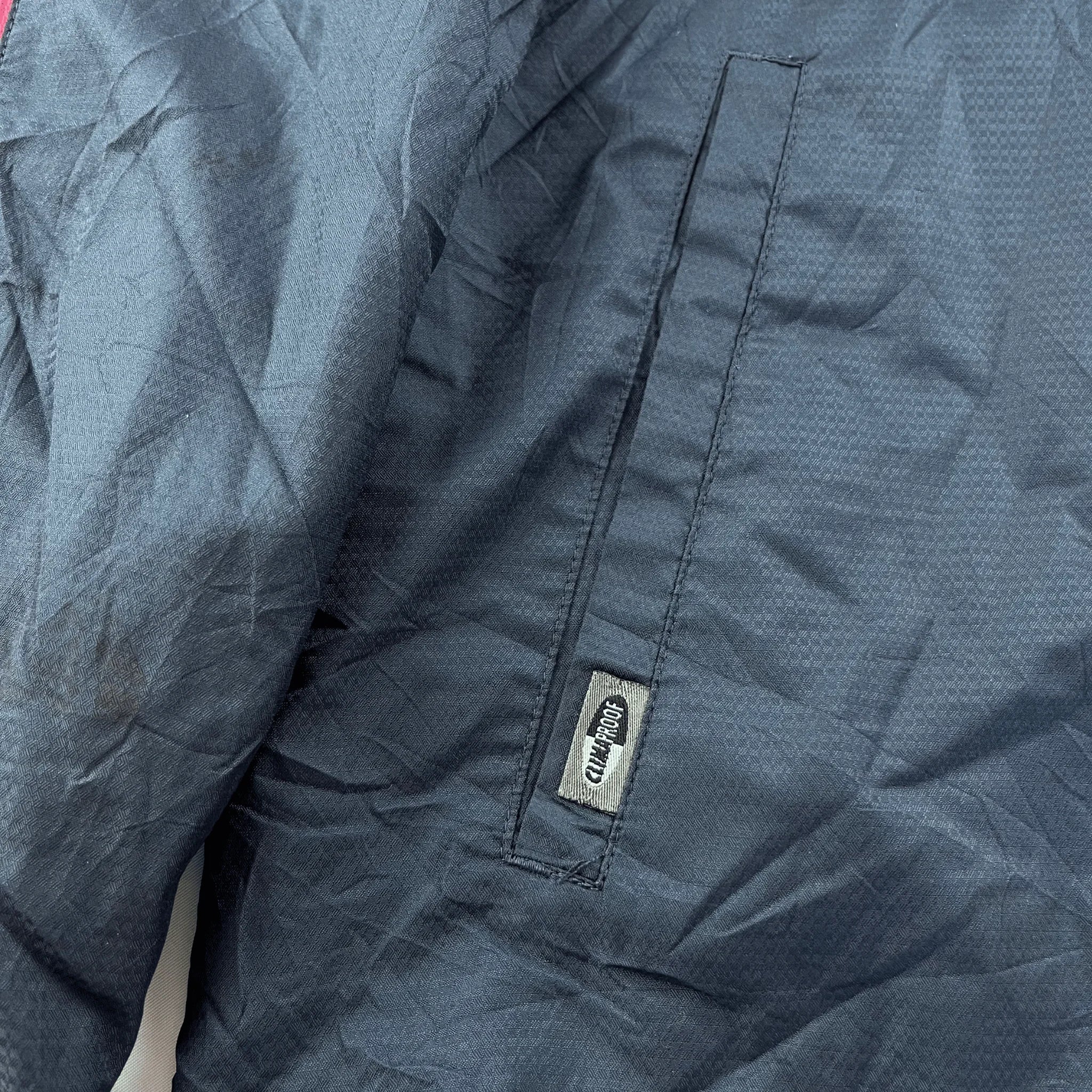 Nahaufnahme einer dunkelblauen Adidas Trainingsjacke Damen Vintage mit Kickvault Logo an der Tasche